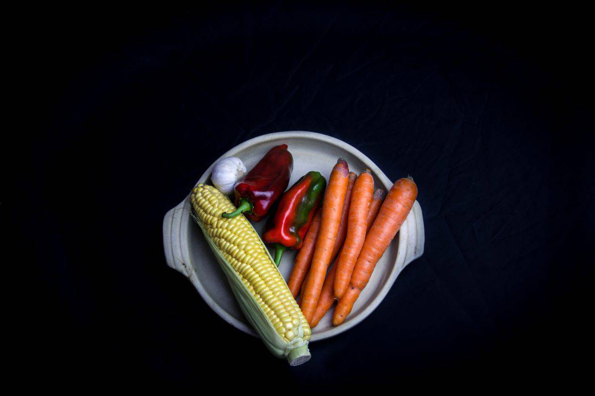 carrots, peppers, corn, and garlic on a plate