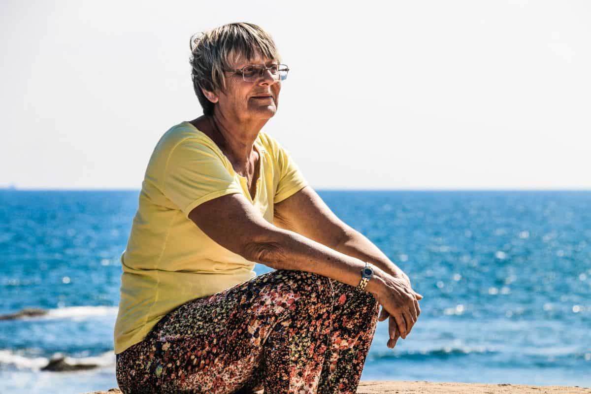 old woman sitting on seashore